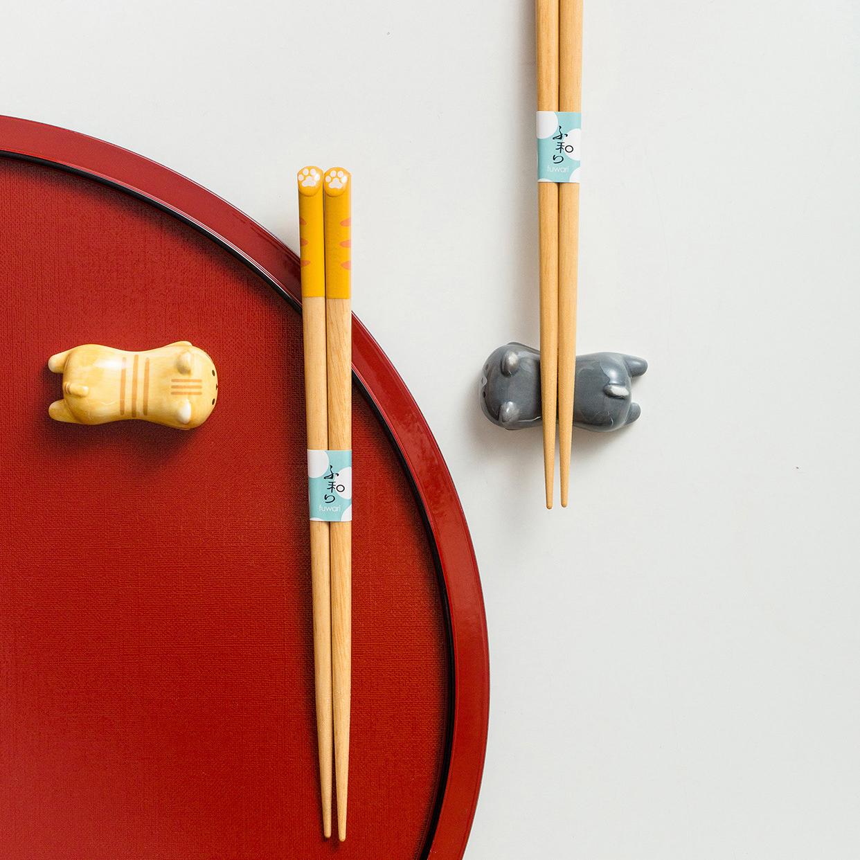 Three sets of wooden cat design chopsticks on a white background