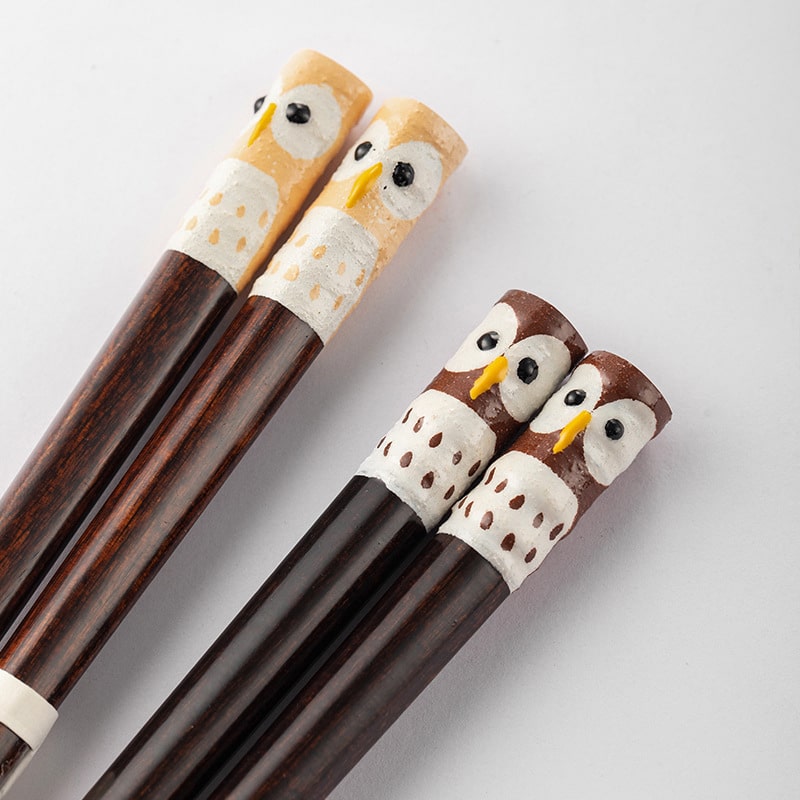Close-up of handcrafted owl design on wooden chopsticks