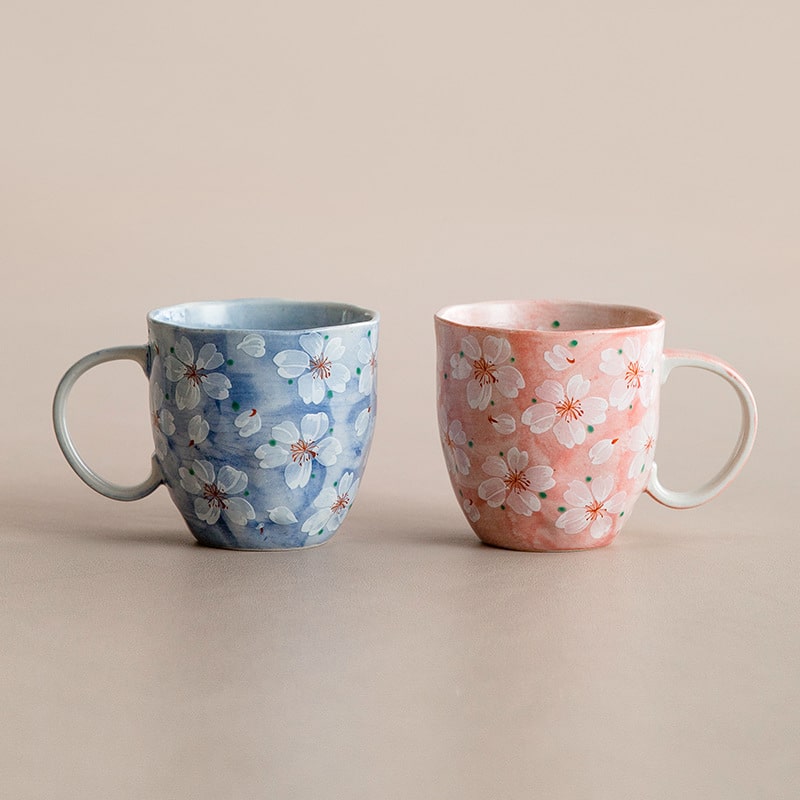 Pair of cherry blossom mugs in pink and blue pastel hues.