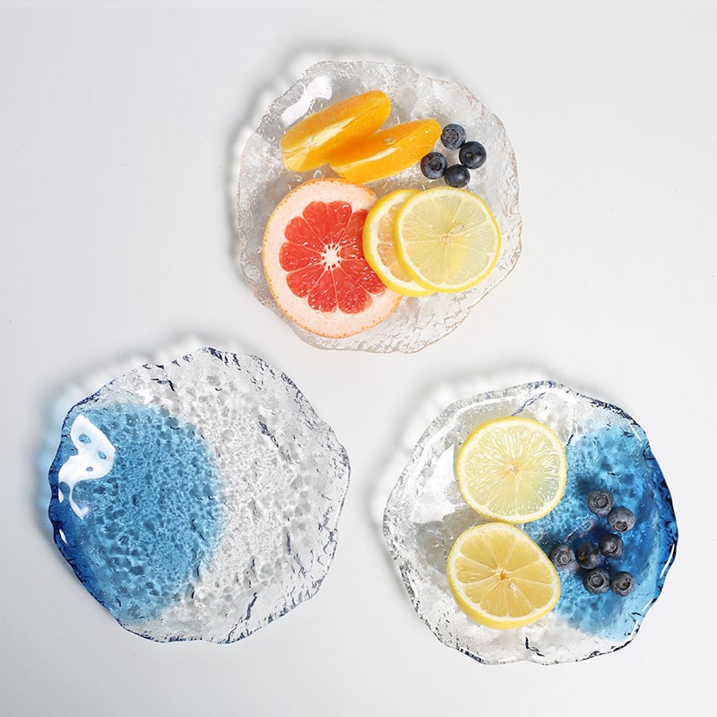 Elegant decorative glass plate holding sliced lemons and berries.