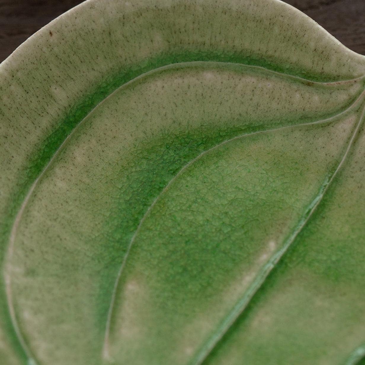 Artistic green ceramic plate with cherries, perfect for serving