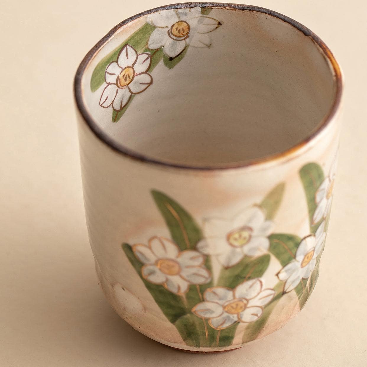 Hand-painted ceramic tea cups featuring seasonal floral designs.