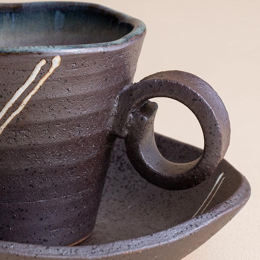 Hand-painted ceramic cup with lavender design and saucer.