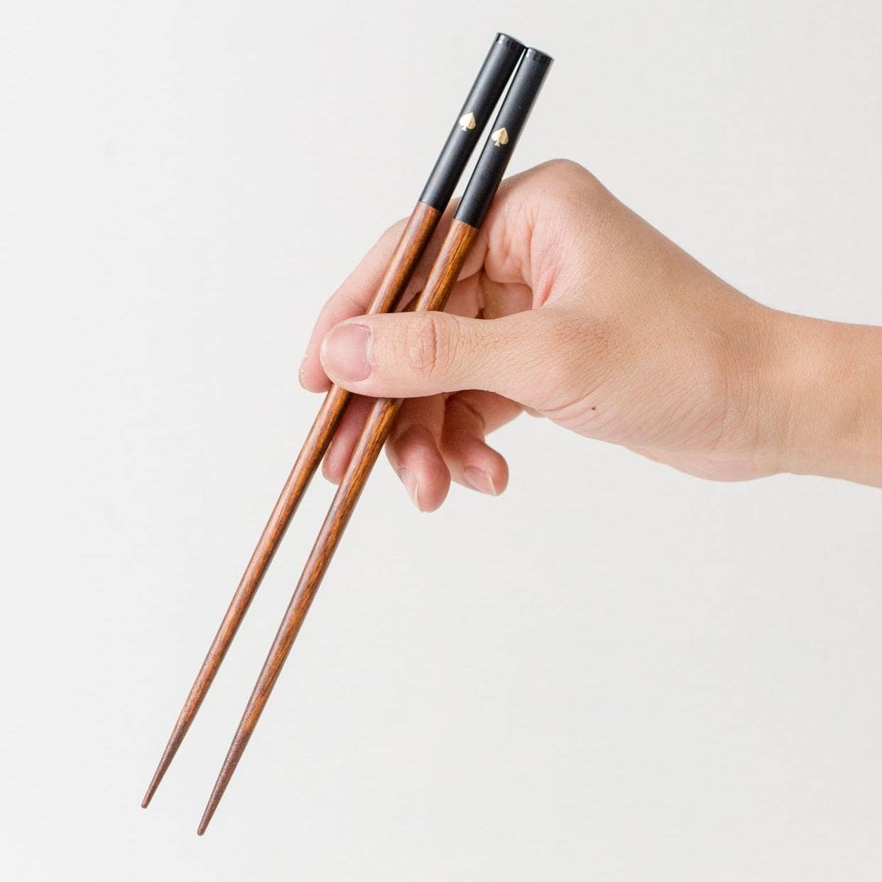 Black and white chopsticks with gold accents displayed on a table