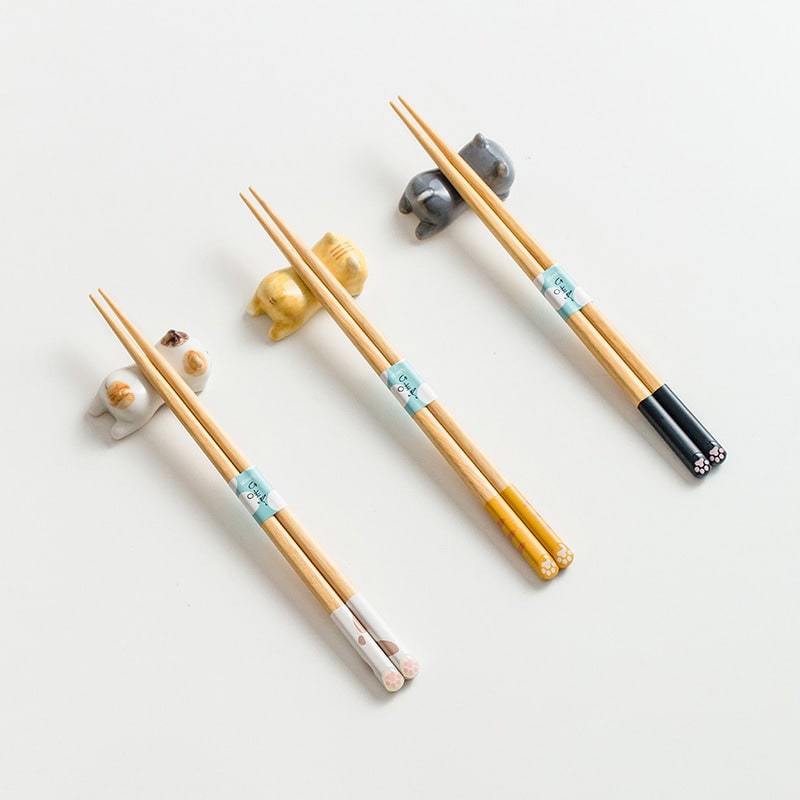 Three sets of wooden cat design chopsticks on a white background