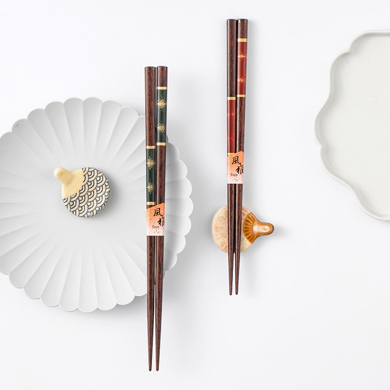 Close-up of gold-inlaid wooden chopsticks in red and green