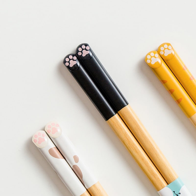 Playful cat-themed chopsticks resting on ceramic holders