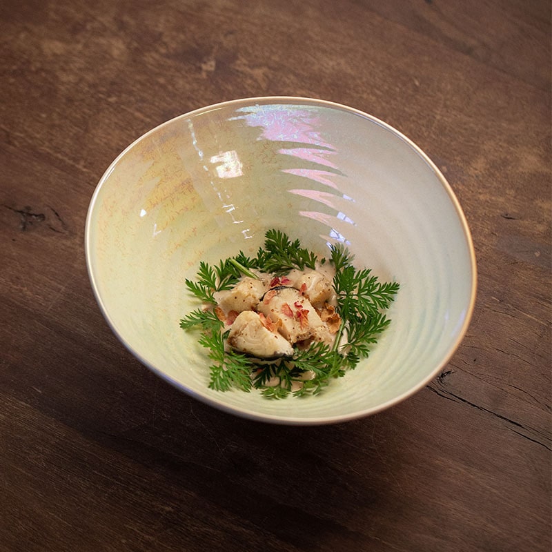 Iridescent ceramic bowl on wooden table