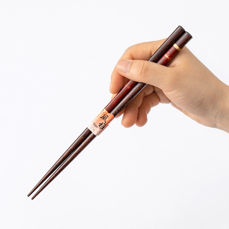 Luxurious wooden chopsticks with gold details on white plate