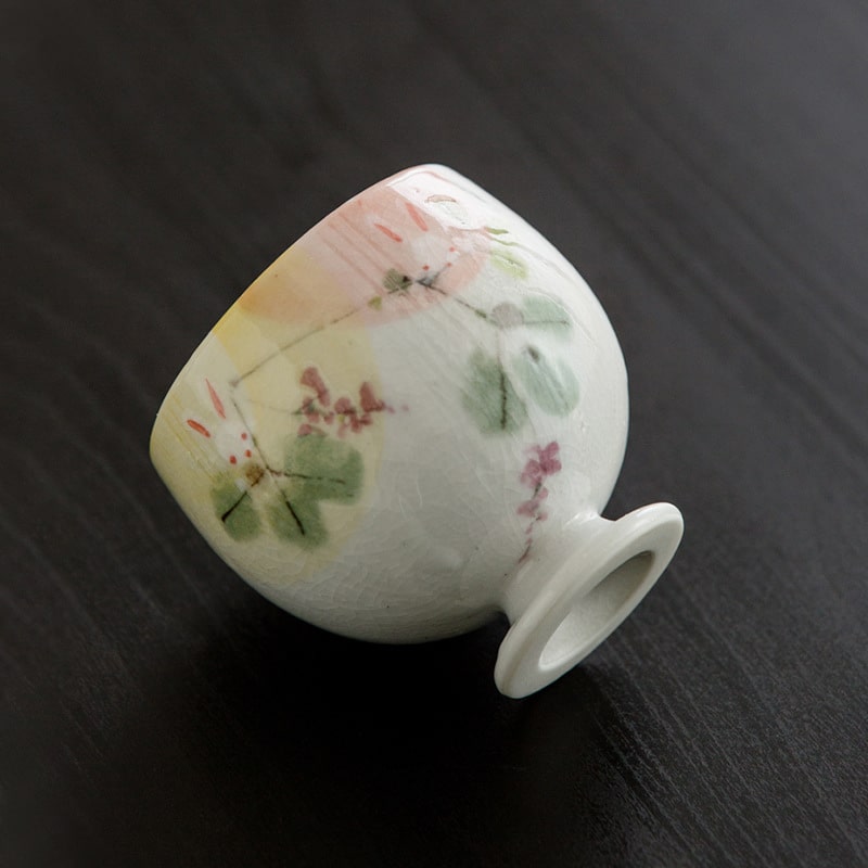 Ceramic cup featuring bunny and flower motifs on a footed base