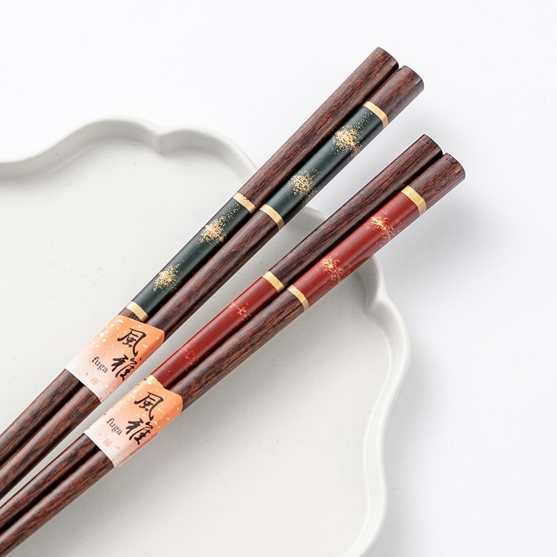 Hand holding premium gold-accented wooden chopsticks