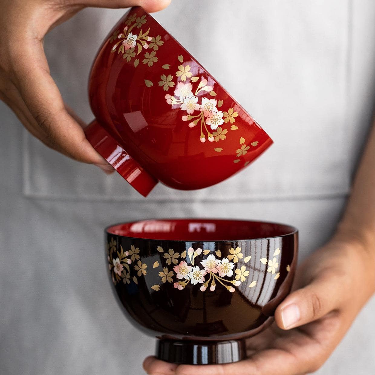 Close-up of red and black cherry blossom lacquerware bowls