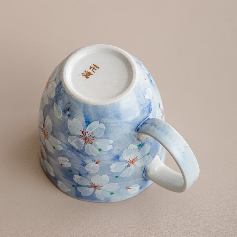 Base of the blue ceramic coffee cup with cherry blossom design.