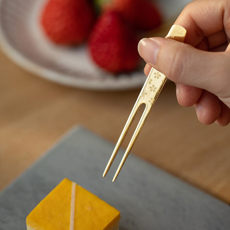 Close-up of the floral-etched gold dessert fork