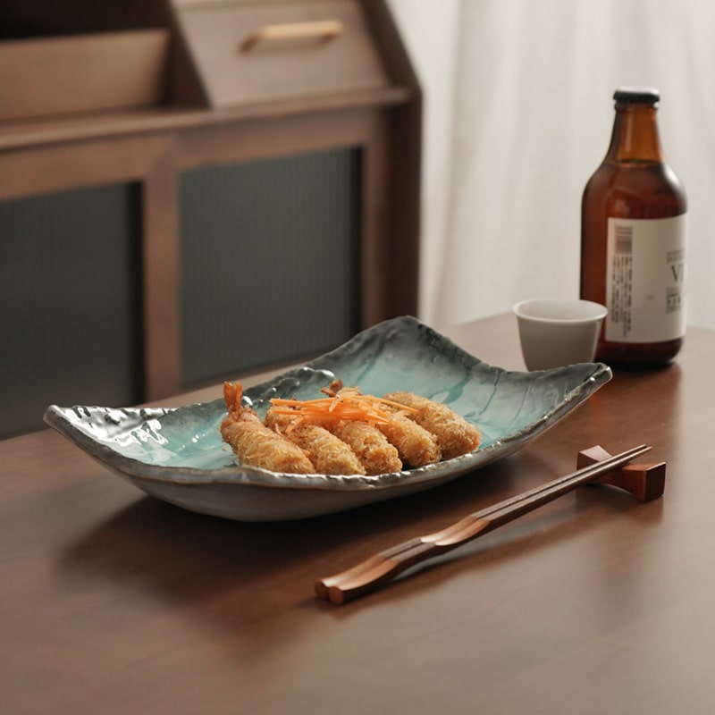 Vibrant turquoise ceramic long plate with fried appetizers.