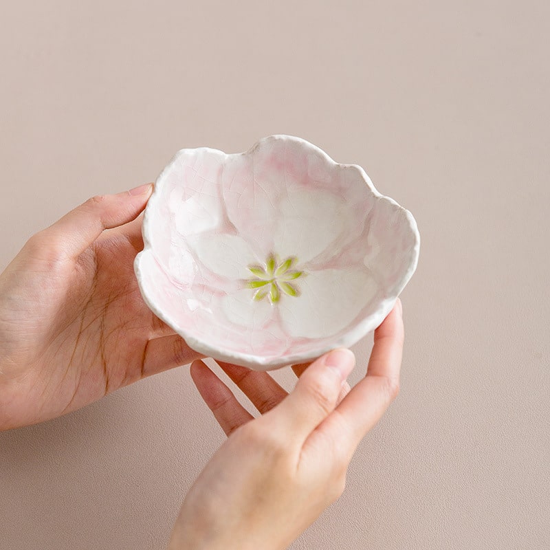Pink flower-shaped small ceramic dish held in hands