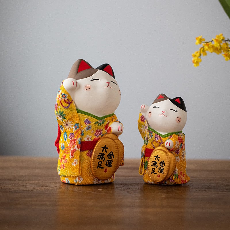 Adorable prosperity cat figurines displayed on a shelf.