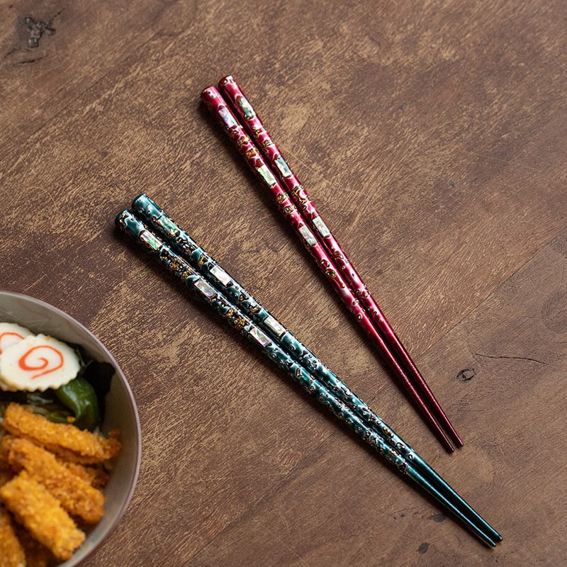 Elegant Japanese chopsticks displayed with sushi on a wooden table.