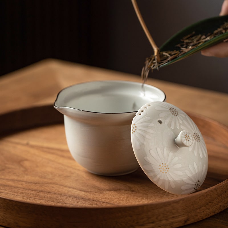 Close-up of floral-patterned Kiyomizu-yaki teacup in white and yellow.