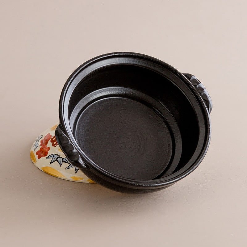 Japanese earthenware cooking pot displayed on a gas stove.