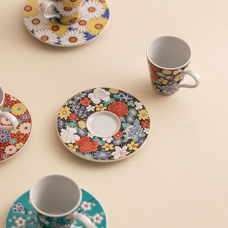 Four espresso cups with distinct vibrant floral designs