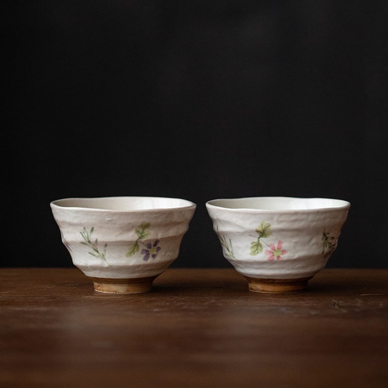 Stack of floral ceramic bowls on a table with chopsticks