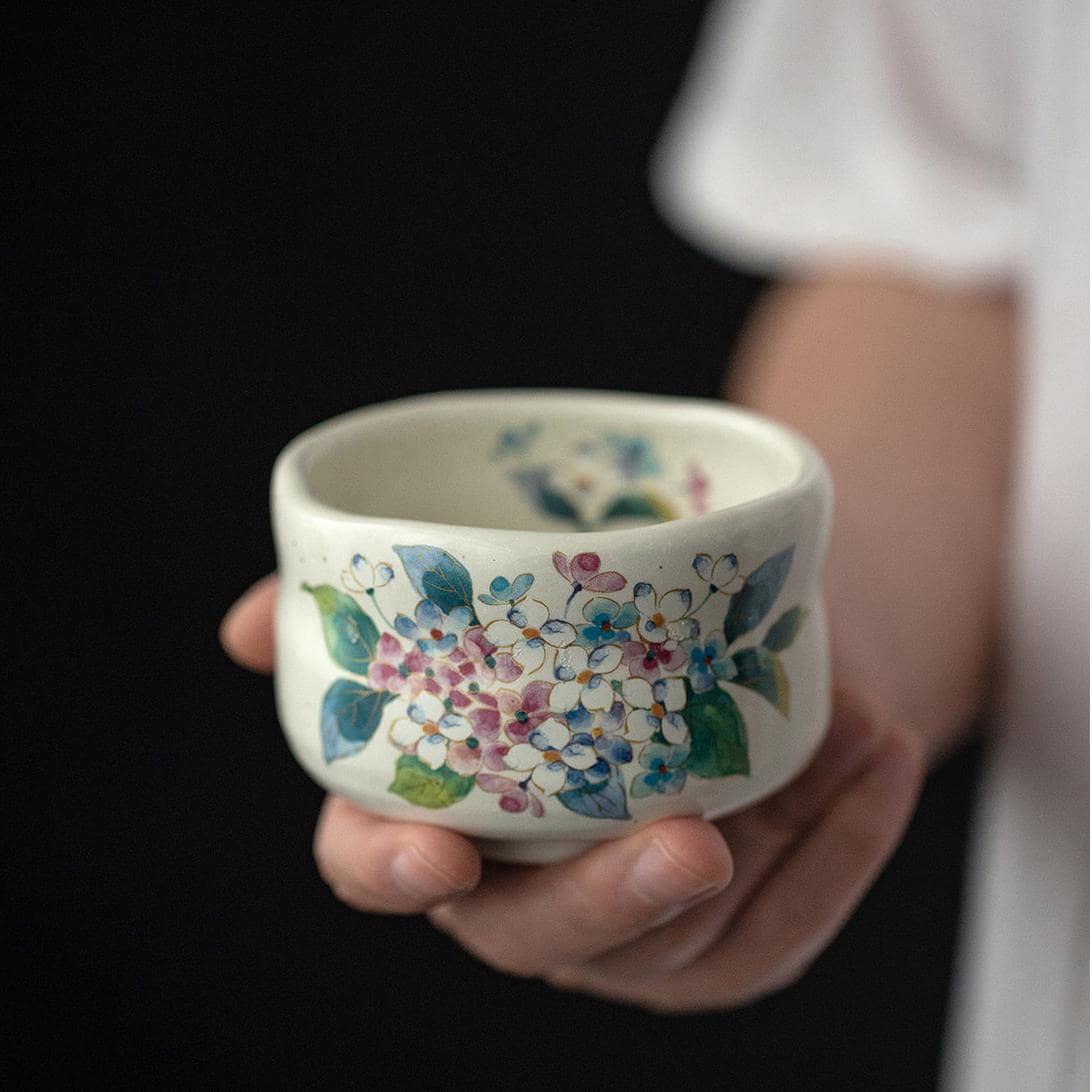 Black ceramic tea cups with gold floral designs