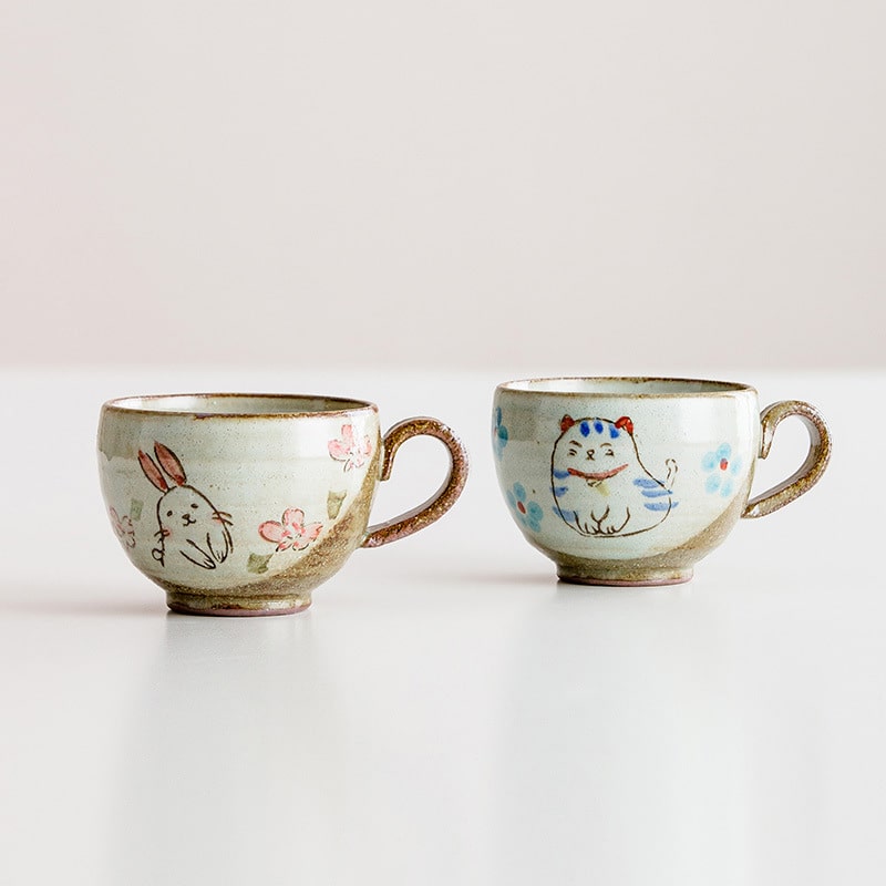 Hand-painted ceramic cup with a rabbit illustration and floral design.