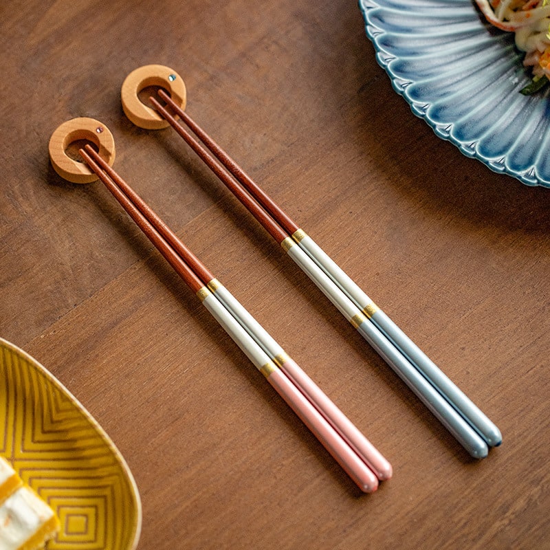 Japanese handmade chopsticks with dual-tone design on a dining table.