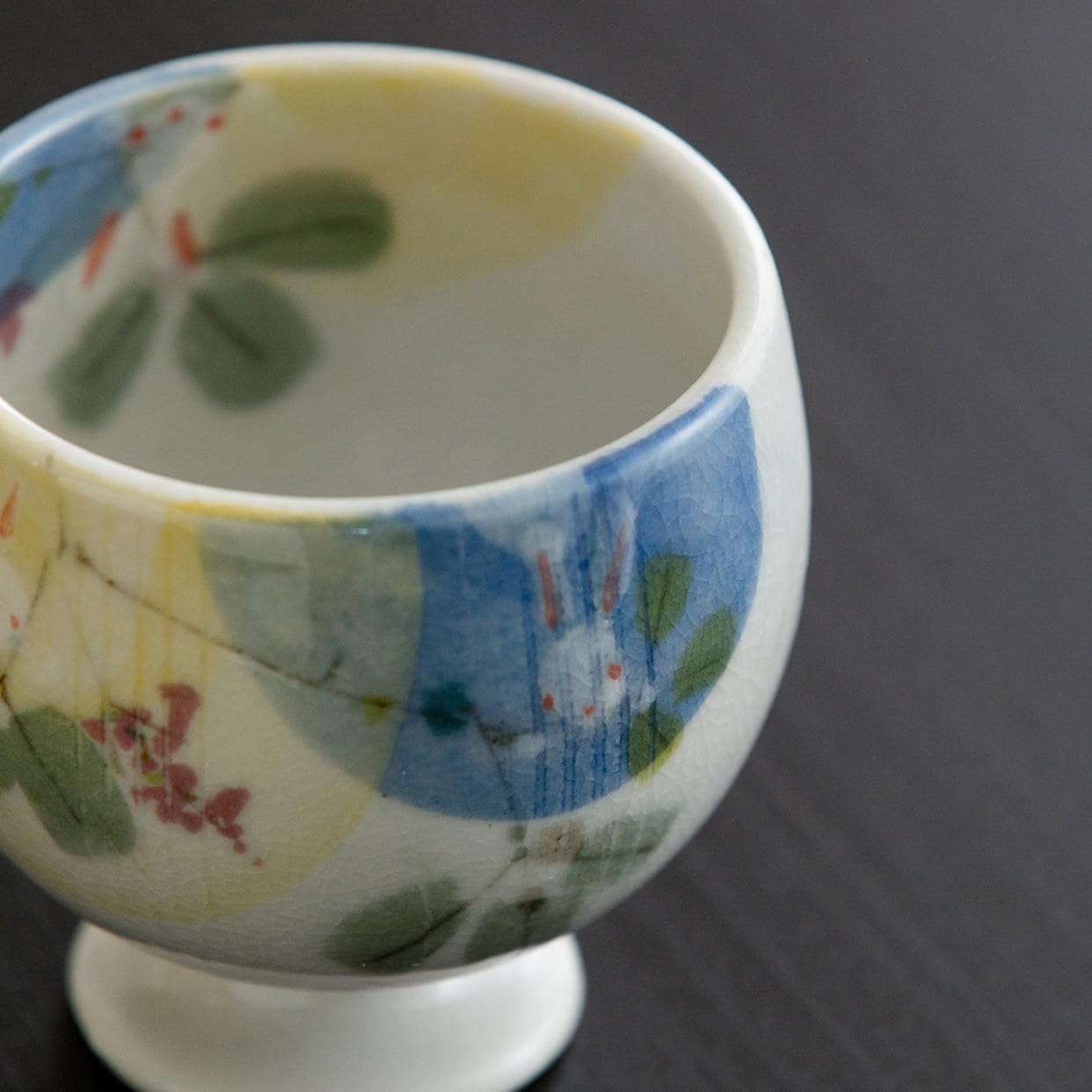 Artistic ceramic cup showcasing pastel floral and animal accents