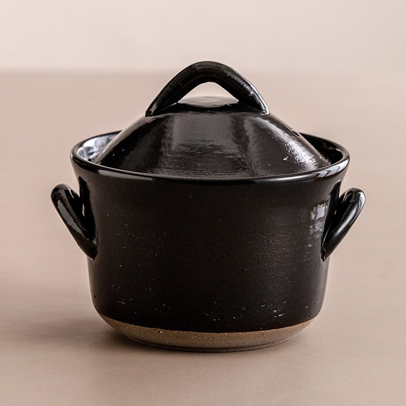 Black ceramic casserole with ergonomic handles and lid.