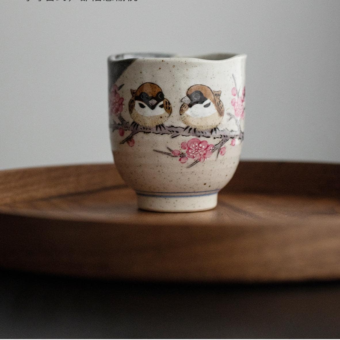 Close-up of hand-painted sparrows on a ceramic tea cup.