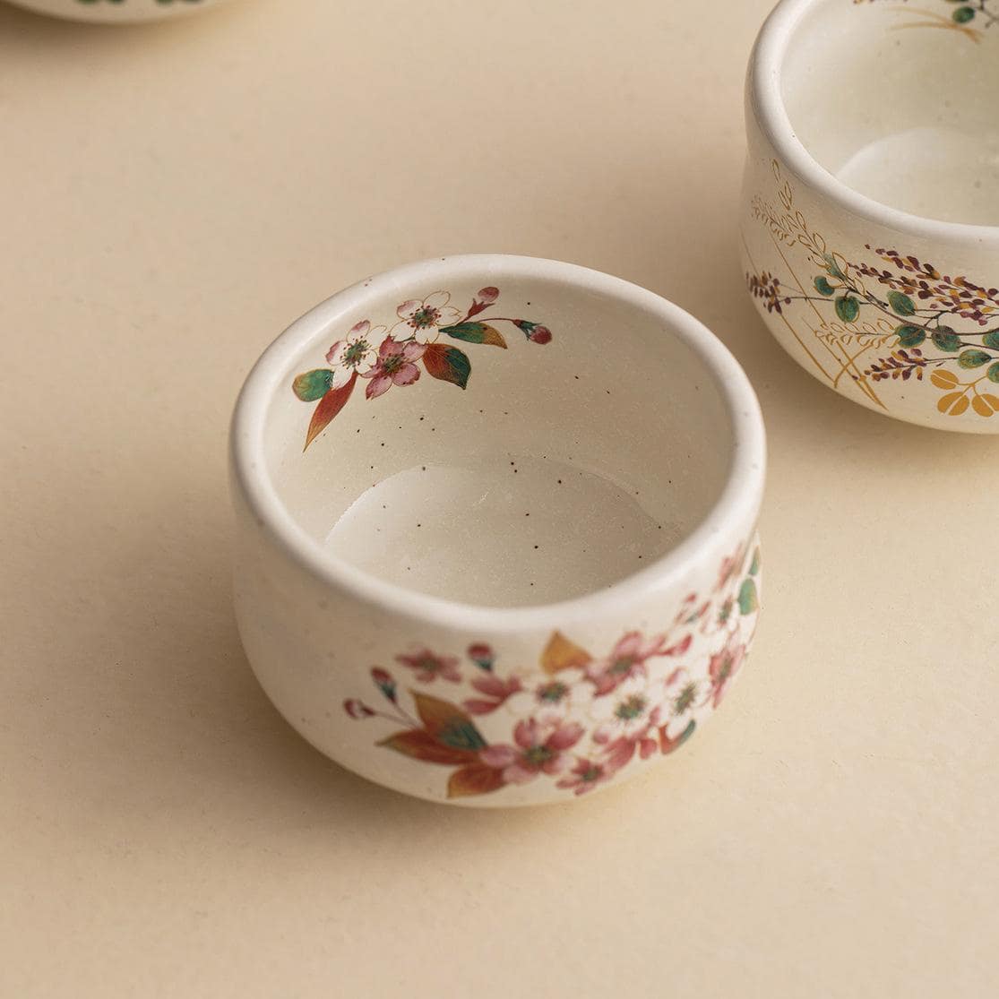 Close-up of a black ceramic cup showcasing intricate gold flower detailing