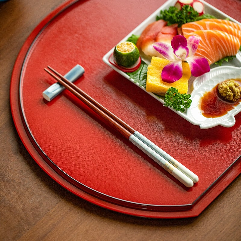 Couple’s chopsticks displayed with colorful plated dishes.