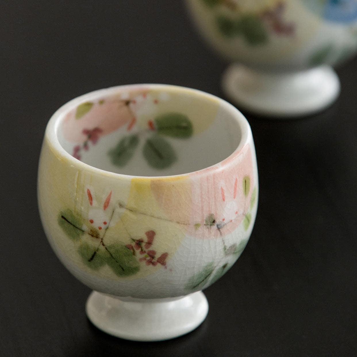 Miniature hand-painted ceramic cup with pastel floral design