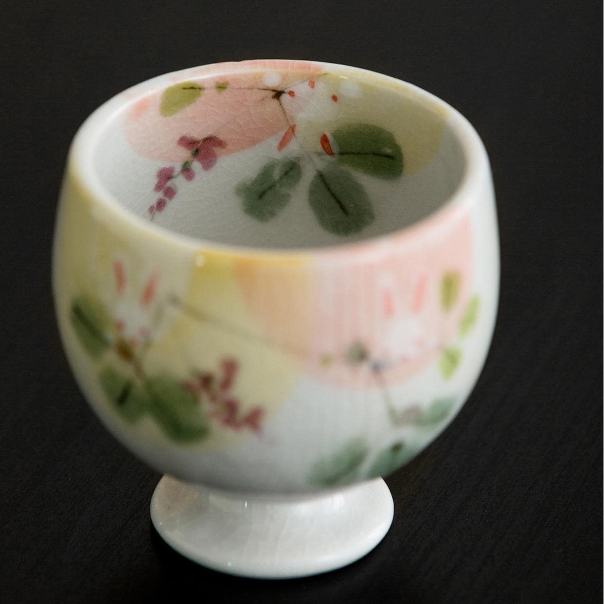 Ceramic cup featuring bunny and flower motifs on a footed base