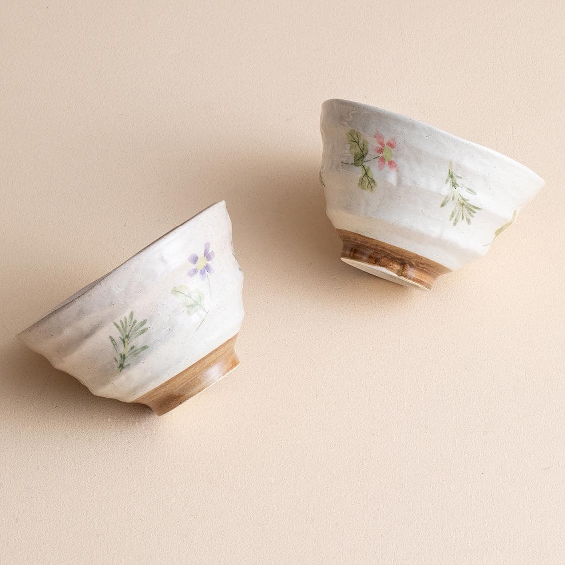 Stack of floral ceramic bowls on a table with chopsticks