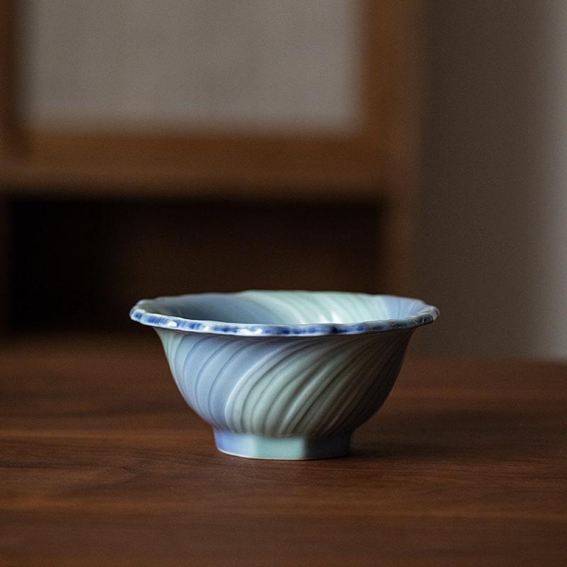 Close-up of flower-shaped ceramic bowl showcasing swirling glaze patterns.