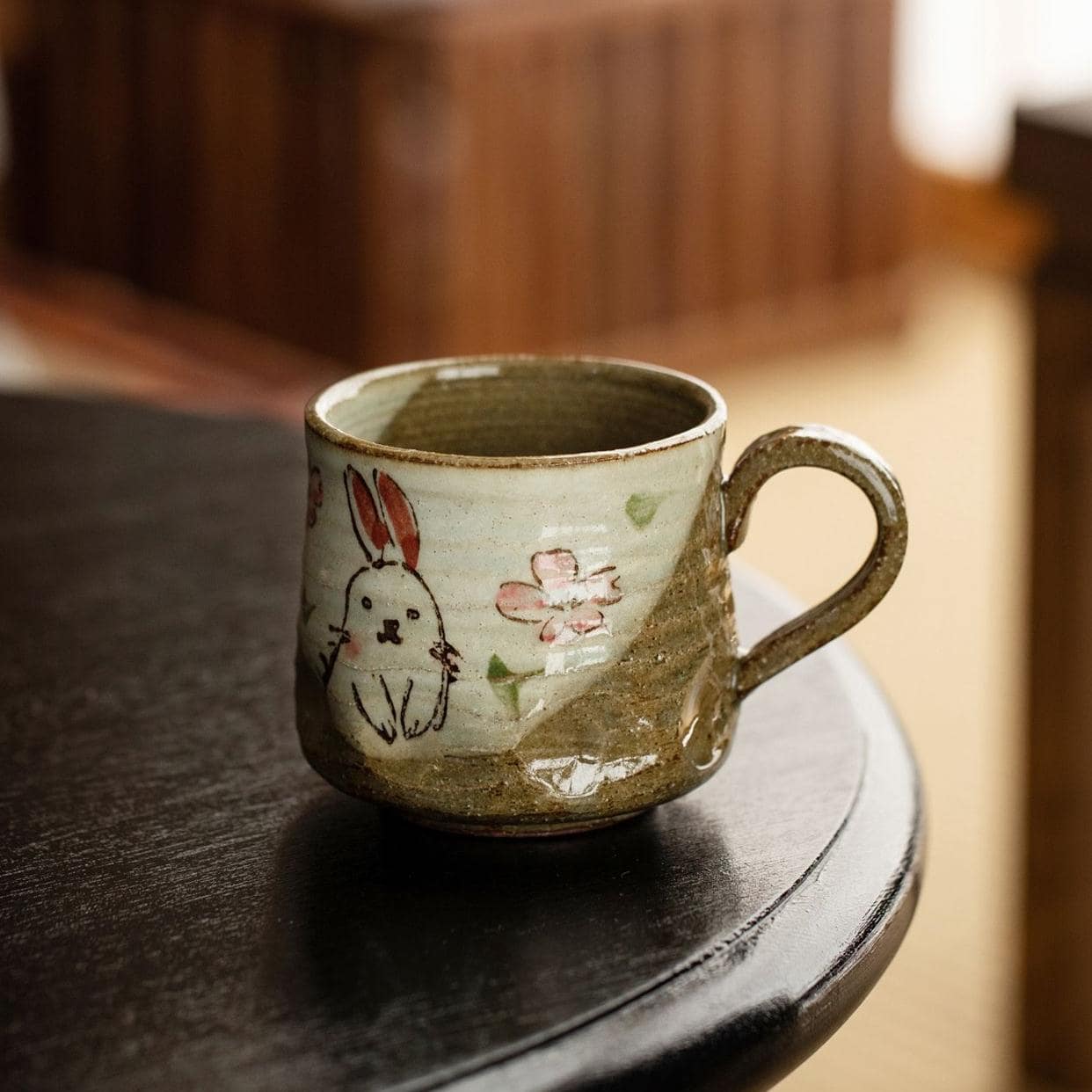 Hand-painted ceramic cup with a rabbit illustration and floral design.