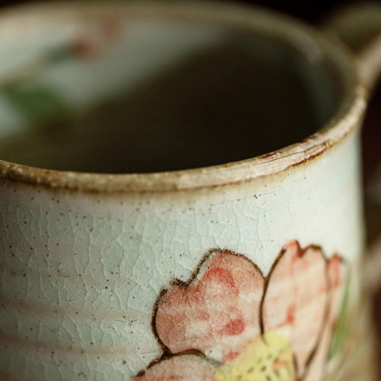 Close-up of a ceramic cup featuring a delicate flower pattern.