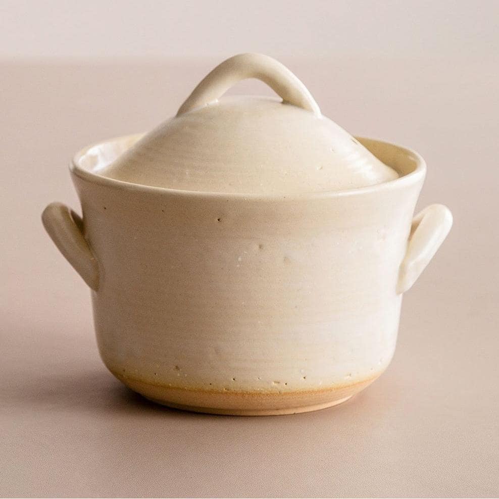 Handcrafted beige ceramic casserole with lid.