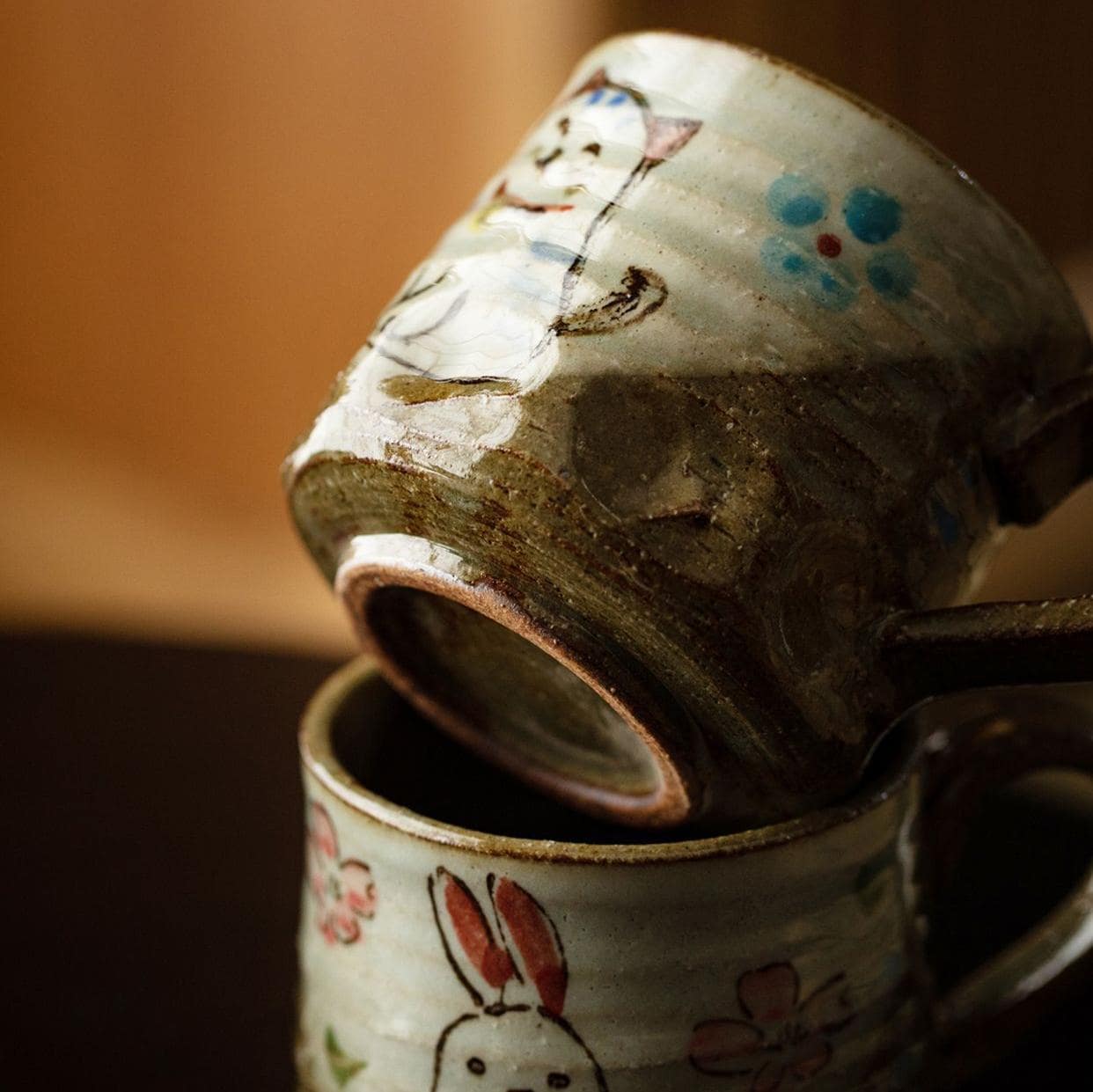 Cat-themed ceramic cup with intricate hand-painted details.