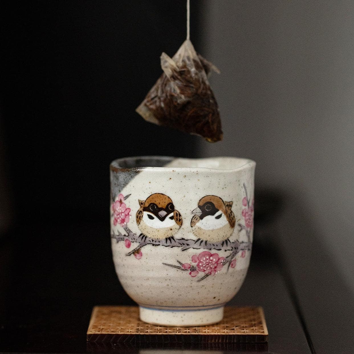 Close-up of hand-painted sparrows on a ceramic tea cup.