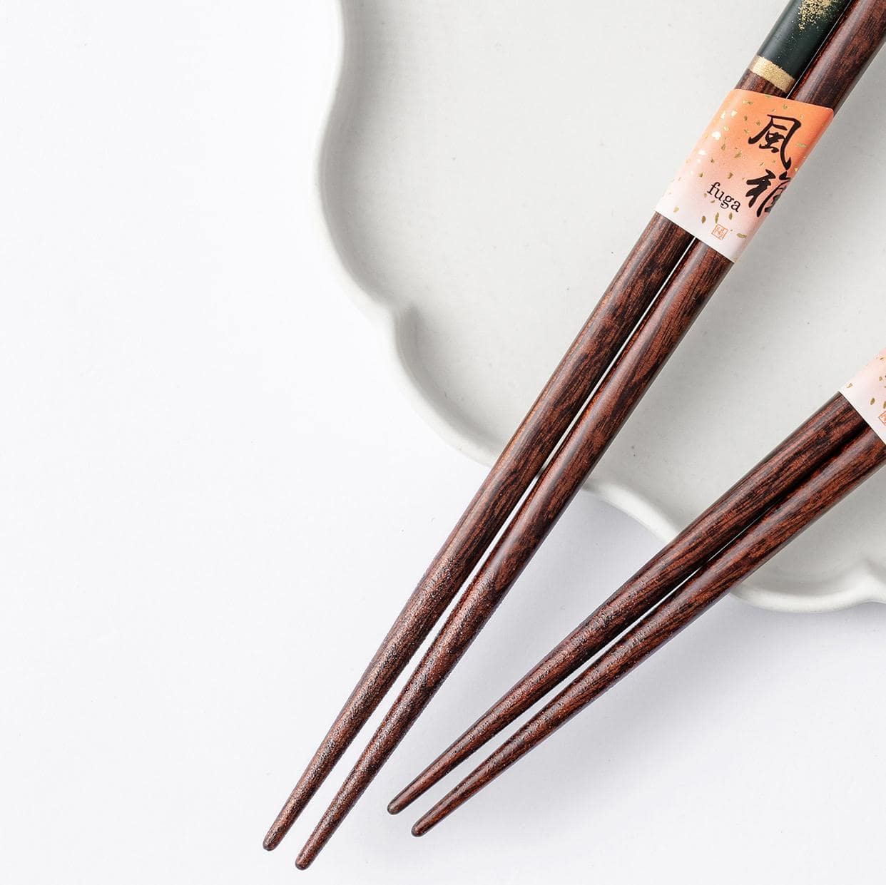 Close-up of gold-inlaid wooden chopsticks in red and green