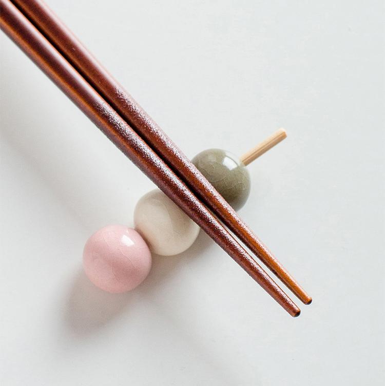 Hand holding Japanese chopsticks with cat designs