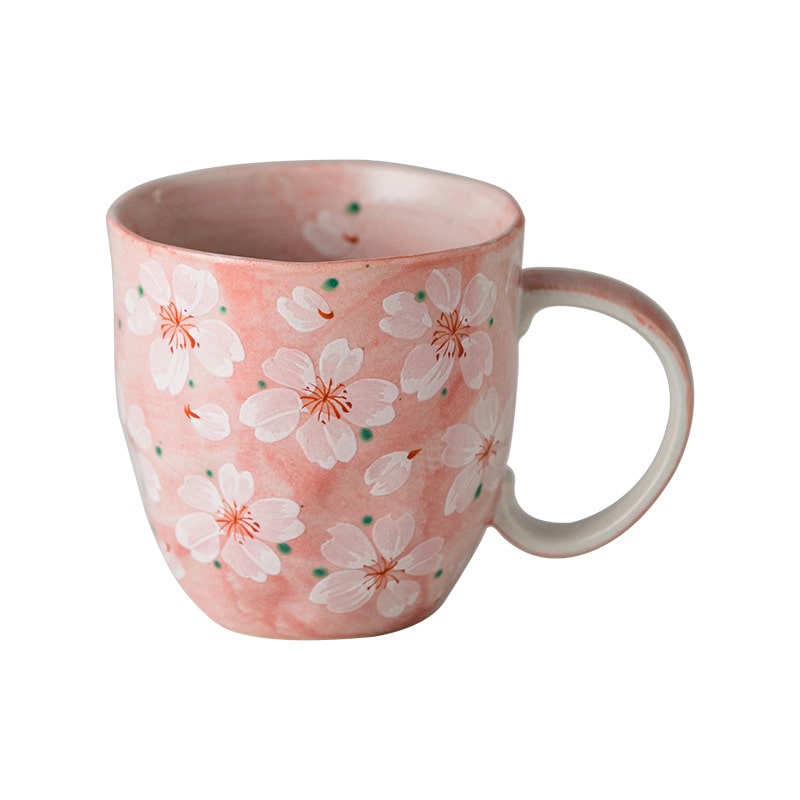 Artistic pink cherry blossom coffee cup, perfect for gifting.