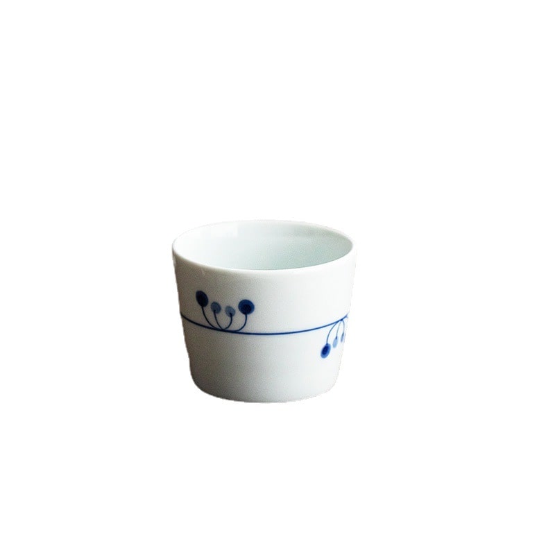 Individual blue and white tea cup with minimalist nature design.