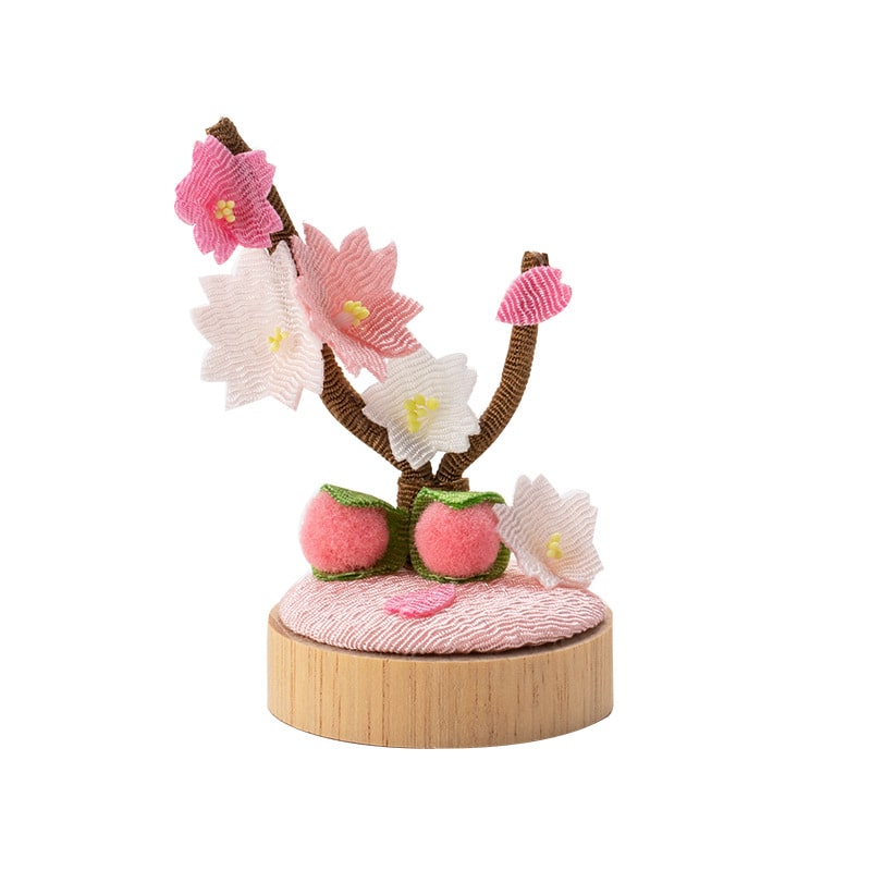 Close-up of delicate fabric flowers on wooden base