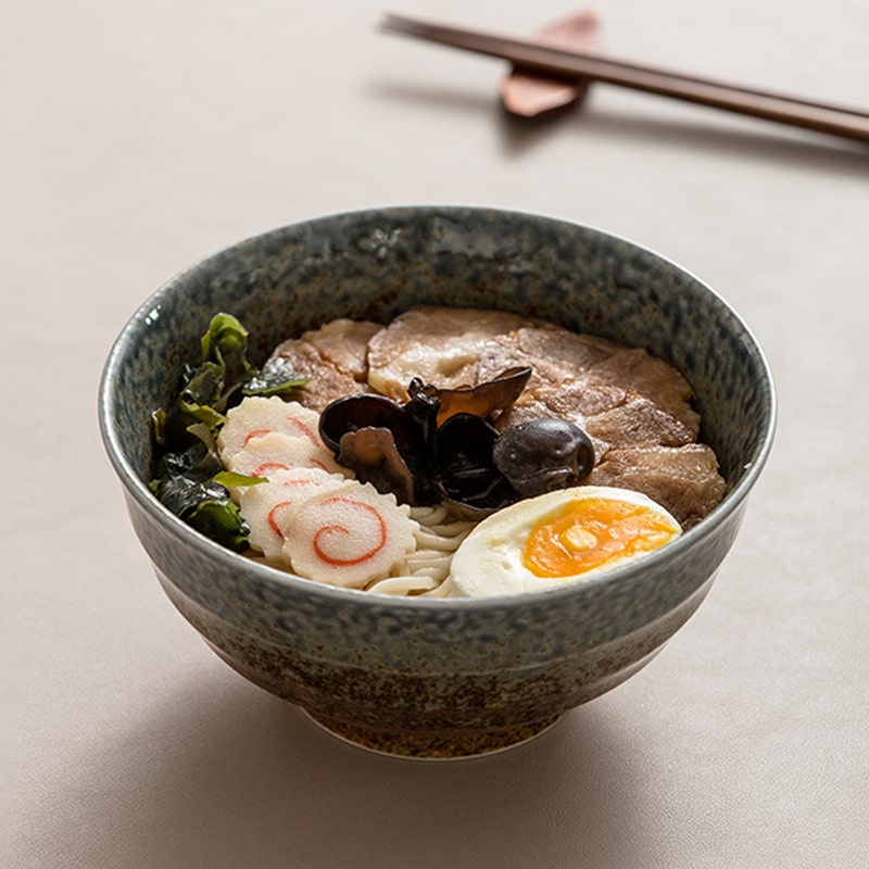 Handmade ceramic bowl filled with ramen and toppings