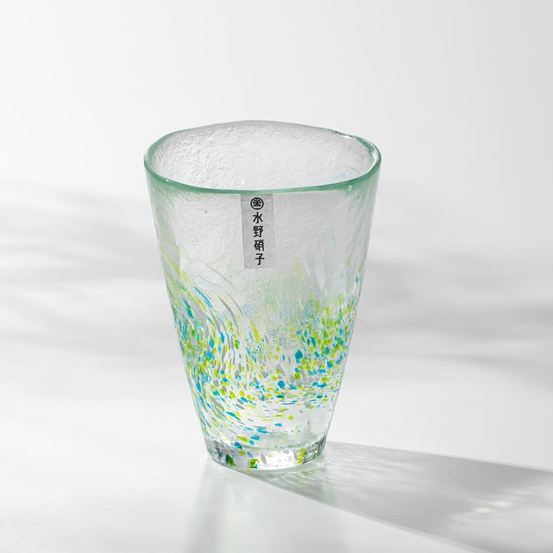 Artistic green and blue glass tumbler in natural light